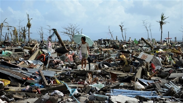 Un mujer camina entre los escombros dejados por el tifón Haiyan en Filipinas.