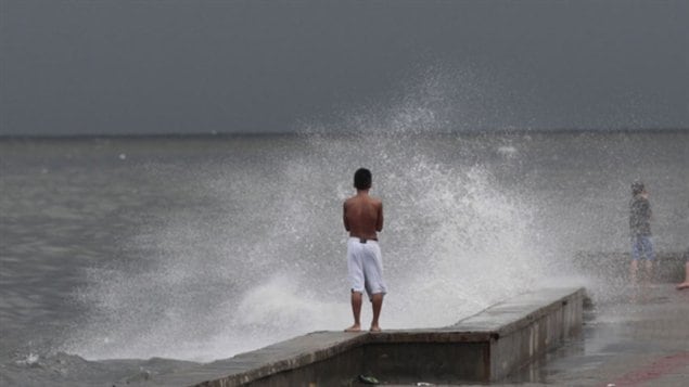 Un jeune garçon surveillait l'approche du typhon vendredi au large des côtes des Philippines. Haiyan a d'abord touché Guiuan à 4 h 45 du matin heure locale avec des vents excédant les 315 km/h, ce qui fait de lui l'un des typhons les plus violents jamais enregistrés au monde. 