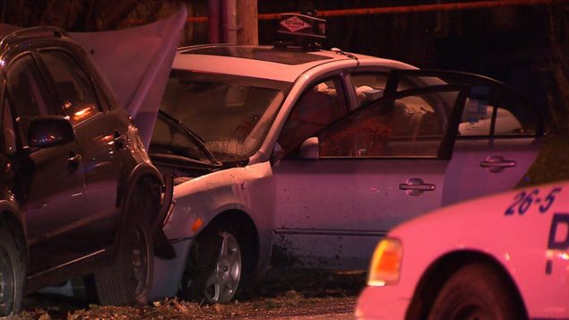 سيارة التاكسي (وسط الصورة) التي قُتل فيها سائقها زياد بوزيد في مونتريال وتبدو في أسفل الصورة جهة اليمين مقدمة سيارة لشرطة مونتريال