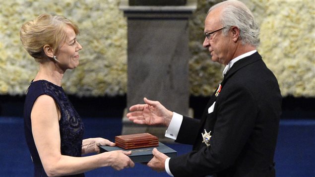 Jenny Munro, la fille d'Alice Munro, lauréate 2013 du prix Nobel de littérature, reçoit la médaille du prix, au nom de sa mère, des mains du roi Charles XVI Gustave de Suède, lors de la cérémonie officielle de remise de prix, le 10 décembre 2013 à Stockholm, en Suède. 