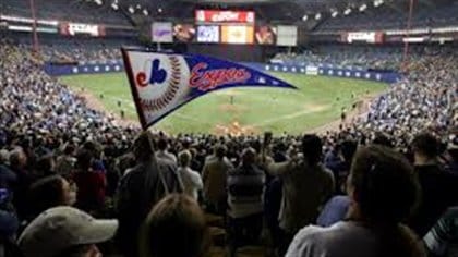 A full house at a packed Olympic Stadium with an blue and white Expos pennant in the foreground.