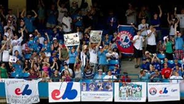 Montreal Expos fans fill an outfield section at the Rogers Centre during a game between the Toronto Blue Jays and the Tampa Bay Rays in Toronto in July. The Montreal fans hope to lure a major league team back to their city. They are holding banners with the Expos logo and appear to be in a very festive mood.