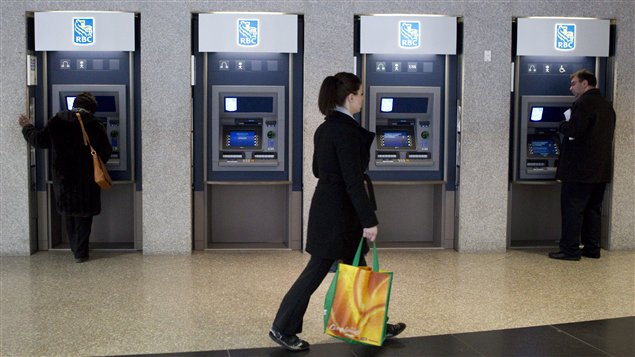 Don't event think about it. A woman, shopping bag in her right hand, makes her way in what appears a determined fashion past a row of four ATMs a customer  at each end. Everyone is dressed for winter and the man at the ATM on the right looks slightly bewildered. It is unclear if he is putting money in or taking it out. But he will very likely have less to play with in 2014.