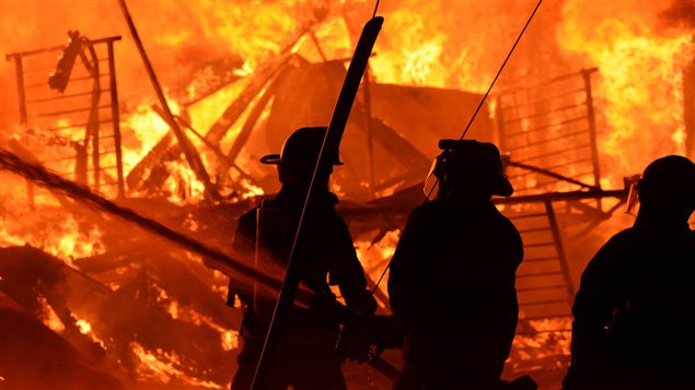 Des pompiers combattent les flammes. Des pompiers combattent les flammes.