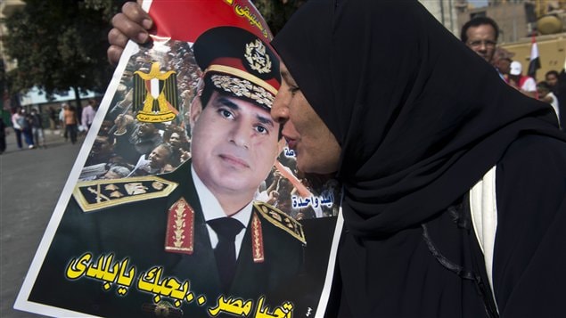 سيدة مصرية تقبل صورة وزير الدفاع وقائد الجيش الفريق أول عبد الفتاح السيسي عند وصولها إلى ميدان التحرير في القاهرة في 6 تشرين الأول (أكتوبر) الفائت لإحياء الذكرى الأربعين لحرب أكتوبر ضد إسرائيل