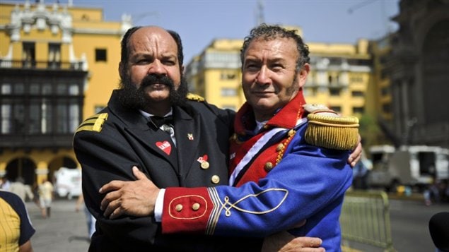 Dos hombres vestidos como los héroes patrios, Miguel Grau de Perú (izq) y Bernardo O’Higgins, de Chile, celebran el fallo de la CIJ en Lima, Perú.