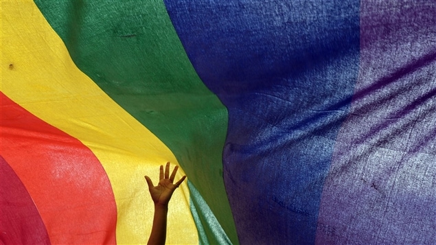 يد تلوح على خلفية علم المثليين