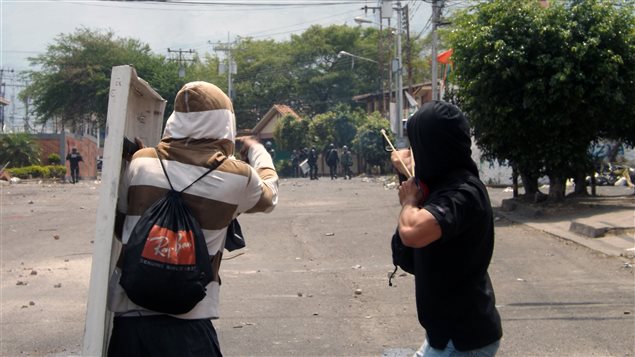 Des opposants au gouvernement de Maduro lancent des pierres lors d'une manifestation à San Cristobal, au Venezuela.