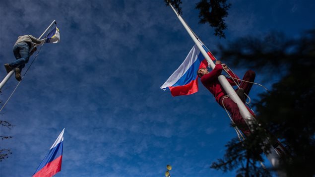 Militantes pro rusos arrían la bandera ucraniana para izar la rusa en el cuartel general de la marina ucraniana en Crimea. 