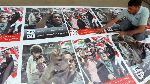 عامل مطبعة في بغداد  يحضّر ملصقات إعلانيّة تحمل صور مرشّحين للانتخابات النيابيّة 