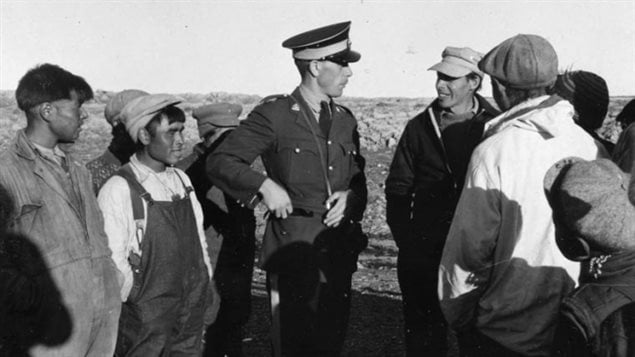 Un officier de la Gendarmerie royale du Canada s'entretient avec un groupe d'Inuits des îles Belcher, en 1949. Un officier de la Gendarmerie royale du Canada s'entretient avec un groupe d'Inuits des îles Belcher, en 1949.