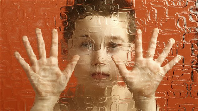 Un enfant derrière un mur de vitre