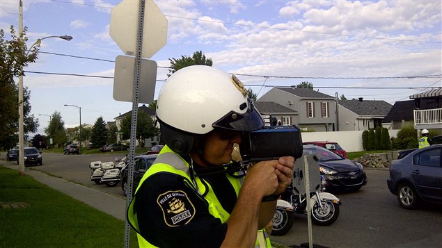 شرطي يشارك في عمليّة لمكافحة السرعة أثناء قيادة السيّارة