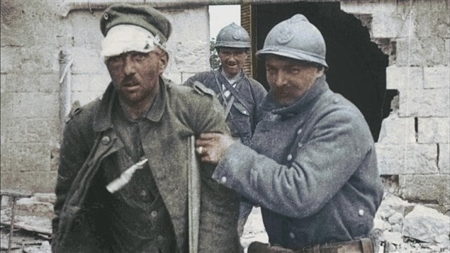 1916. Un soldat allemand blessé pendant les combats est pris en charge par un'poilu'. 1916. Un soldat allemand blessé pendant les combats est pris en charge par un'poilu'.