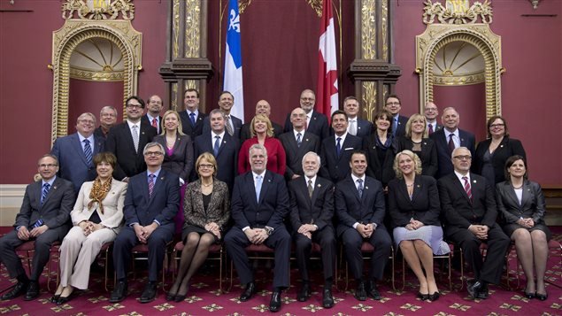 رئيس الحكومة الكيبيكيّة فيليب كويار ( الخامس من اليسار في الصف الأمامي) مع أعضاء حكومته في مقر الجمعيّة الوطنيّة في كيبيك