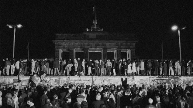 Des Allemands de l’Est et de l’Ouest célèbrent la chute du mur de Berlin et l’ouverture de frontière est-allemande à la porte de Brandebourg, le 9 novembre 1989. Des Allemands de l’Est et de l’Ouest célèbrent la chute du mur de Berlin et l’ouverture de frontière est-allemande à la porte de Brandebourg, le 9 novembre 1989.