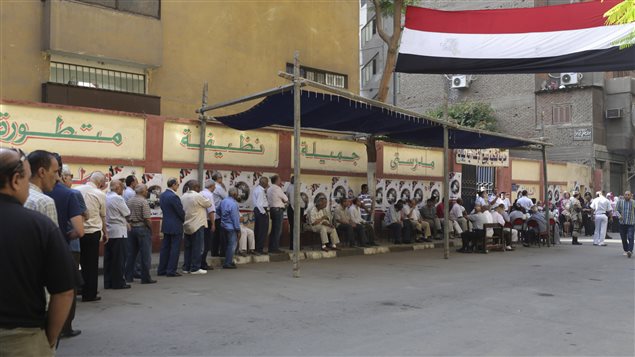 ناخبون مصريون ينتظرون دورهم للإدلاء بأصواتهم اليوم أمام أحد مراكز الاقتراع في القاهرة