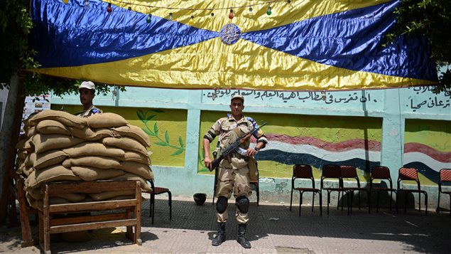 جنديان مصريان يقومان بحراسة مكتب اقتراع اليوم في إحدى ضواحي القاهرة