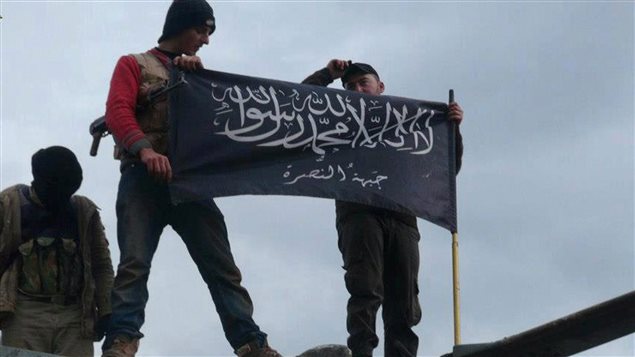 Des membres du groupe islamiste Al-Nusra brandissent le drapeau de leur brigade en Syrie