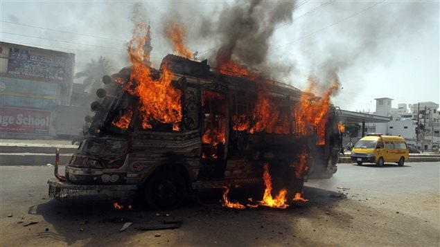 Manifestantes incendiaron un bus en Karachi al anuncio dela detención en Londres de Altaf Hussain, jefe del MQM.