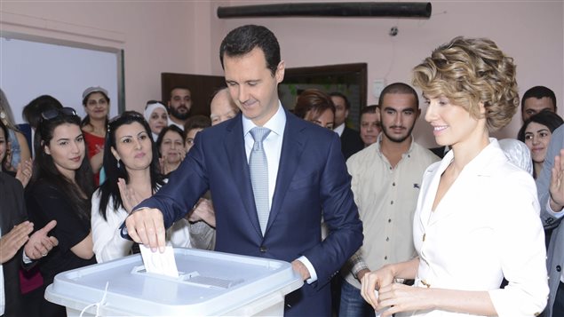 الرئيس السوري بشار الأسد وزوجته أسماء الأخرس يدليان بصوتيهما في الانتخابات الرئاسية أمس في مركز اقتراع في دمشق