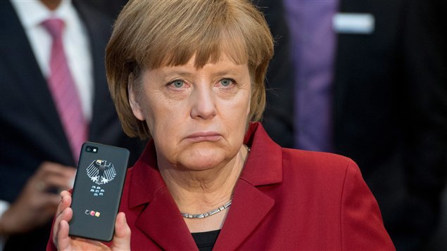 La chancelière allemande, Angela Merkel, brandit son téléphone 