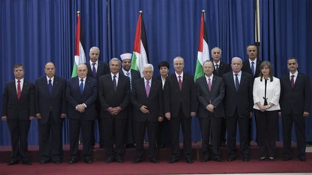 أعضاء حكومة التوافق الفلسطينية خلال حفل أداء القسم في رام الله يوم الاثنين الفائت، ويبدو في الوسط (السادس من اليمين في الصف الأمامي) الرئيس الفلسطيني محمود عبّاس