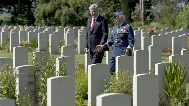 Le premier ministre canadien Stephen Harper s'entretient avec le major général, Richard Rohmer, dans le cimetière canadien de Bény sur mer dans le cadre du 70e anniversaire du débarquement de Normandie.