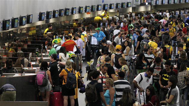 مسافرون في مطار ريو دو جانيرو الذي تواصلت حركته رغم إضراب العمّال (12-06-2014)