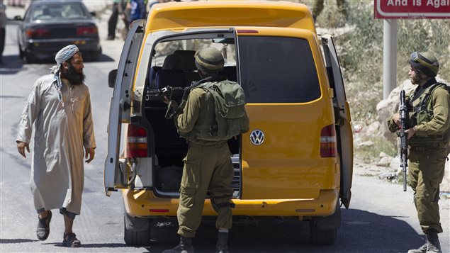 Des soldats isréaliens fouillent un véhicule palestinien près de la ville d'Hébron, en Cisjordanie. 