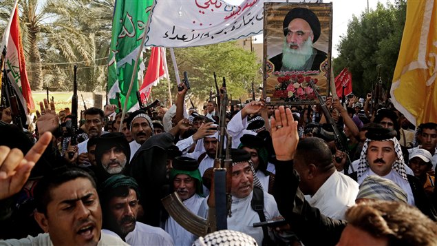 عراقيون شيعة يرفعون صورة لNية الله السيستاني في البصرة ويردّدون هتافات معادية لتنظيم داعش في 16-06-2014