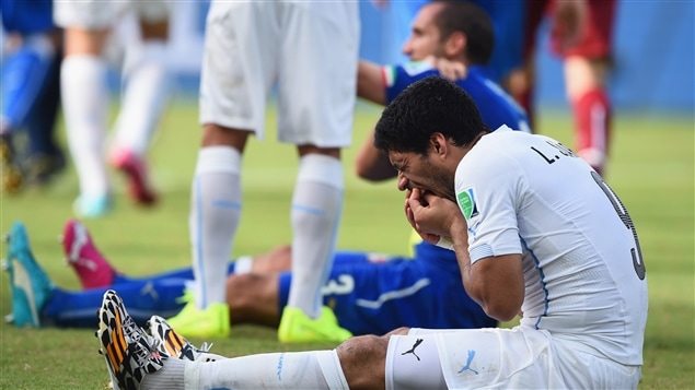 Luis Suarez, de l'Uruguay, exprime sa douleur. En arrière-plan, Giorgio Chiellini se tient une épaule, apparemment mordue par l'Uruguayen.