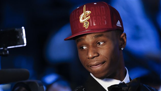 A somewhat bemused Andrew Wiggins in a red Cleveland baseball cap meets the press in New York after being the NBA's top draft choice.