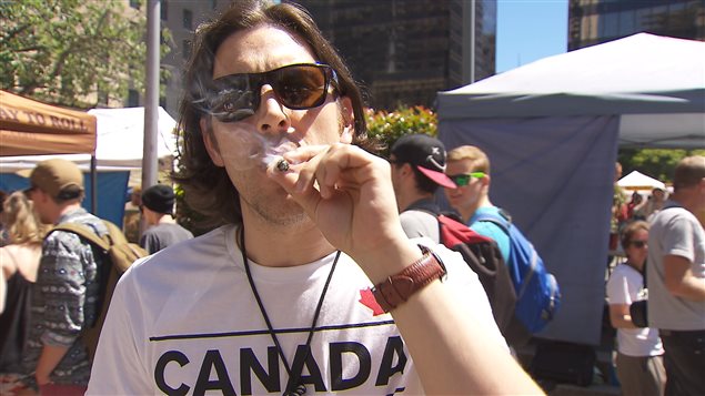 Un jeune homme fume un joint à Vancouver.