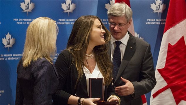 رئيس الحكومة الكندية ستيفن هاربر يقدم واحدة من "جوائز رئيس الحكومة للعمل الطوعي" لإحدى الفائزات في تورونتو في شباط (فبراير) 2014