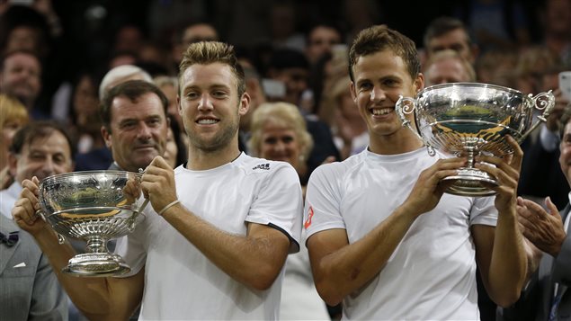 Vasek Pospisil of Canada, right, and Jack Sock of the U.S hold their trophies after defeating Bob Bryan and Mike Bryan of the U.S in the men's doubles final at Wimbledon on Saturday.