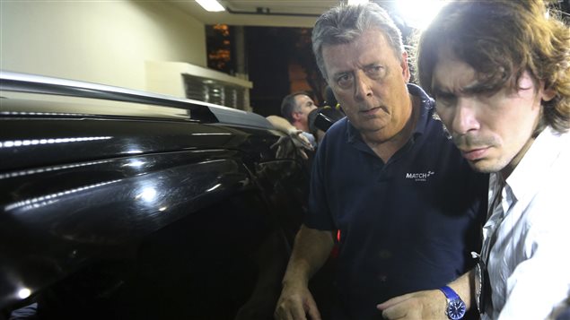 Ray Whelan (izq.) es acompañado por un policía brasileño.