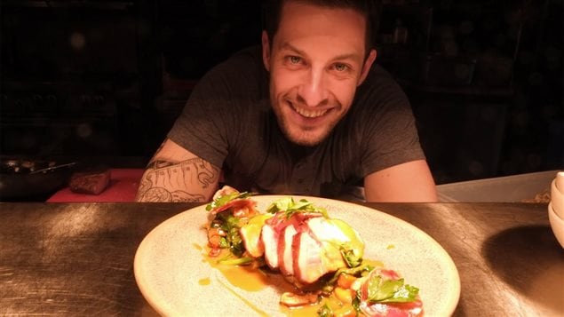 Guillaume St-Pierre du Restaurant La Planque, derrière son assiette de porc