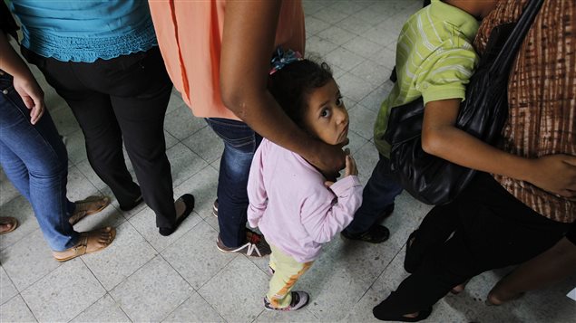 Mujeres y sus hijos hacen cola en un centro de ayuda para migrantes después de haber sido expulsados de México hacia Honduras en junio pasado.