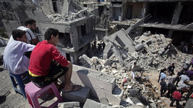 فلسطينيون امام ركام منازل دمّرها القصف الإسرائيلي على خان يونس في 10 تموز يوليو 2014