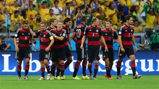 German players know they have their hands full this weekend against Lionel Messi and Argentina. The players--nine strong--are shown after scoring one of their seven goals against Brazil on Tuesday. They are wearing red and white horizontally stripped jerseys with black shorts. Behind them are a sea of Brazilian fans dressed in their traditional yellow.
