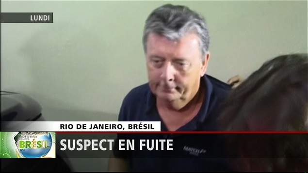 Ray Whelan est escorté par un policier brésilien