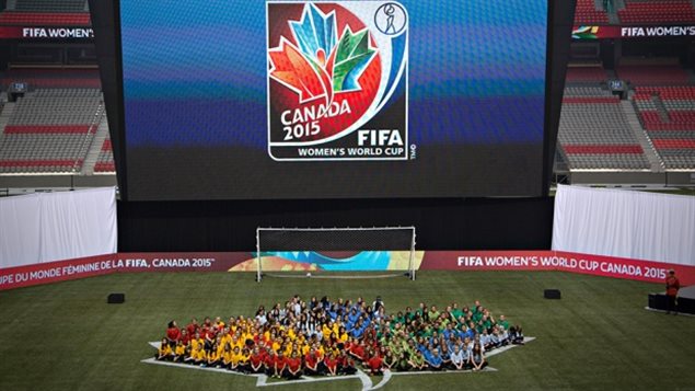 Young soccer players form the logo for the 2015 FIFA Women's World Cup during its unveiling in Vancouver in December 2012. A shot from high up with the kids forming a maple leaf on a stadium floor. Over them is a giant video screen showing a maple leaf logo under which is written "Canada 2015."