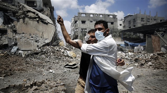 طبيب يسعف مصاباً أمس في حي الشجاعية في مدينة غزة