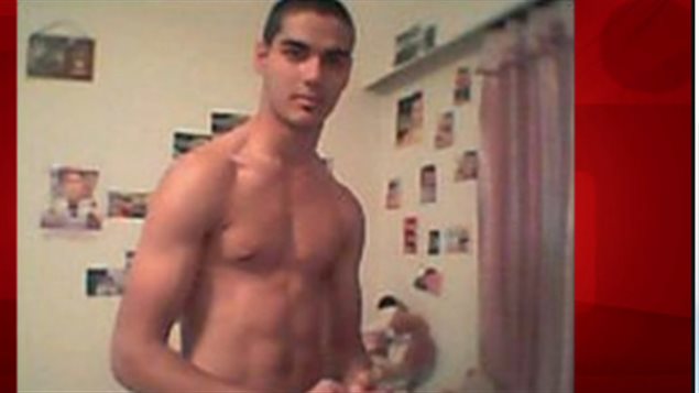 Neighbours say the man in the picture is 25-year-old Hasibullah Yusufzai, who was charged Wednesday for travelling to join a terrorist group. He is the first Canadian to be charged under the 2013 law. Mr. Yusufzai is shown from the waste up posing bare-chested in what appears to be a bathroom. To his left is a crimson curtain that hangs beside a flimsier grey curtain. Behind him on two intersecting grey walls are numerous snapshots and slightly larger photos that are out of focus to the viewer. He has short, black hair, is clean-shaven and appears athletic as he is thing with a good build. 