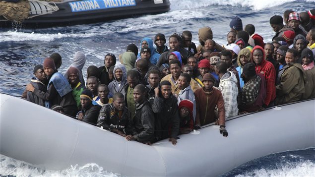 Des migrants dans un bateau de sauvetage italien après une opération de sauvetage au large de la Sicile, le 28 novembre 2013