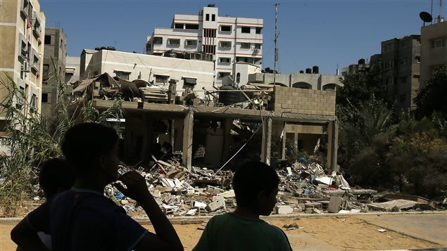 Des garçons observent une maison bombardée par des raids aériens israéliens à Gaza, le 27 juillet 2014