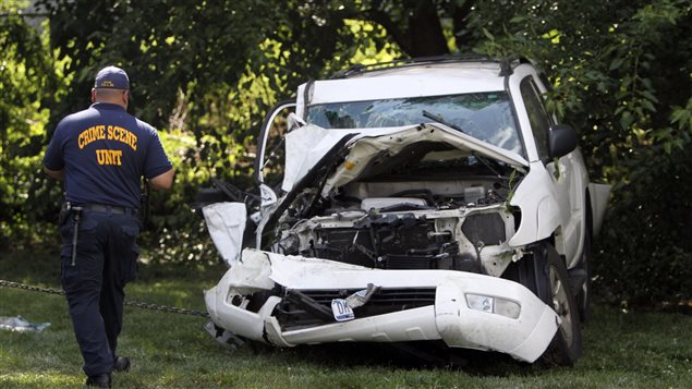 محقّق يتفحّص سيّارة متضرّرة من جرّاء حادث سير وقع شمال فيلادلفيا في الولايات المتحدة في 22 تموز يوليو 2014