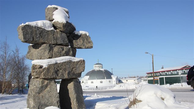 An Inuit inukshuk is pictured in downtown Inuvik with the town's igloo shaped church in the background. 