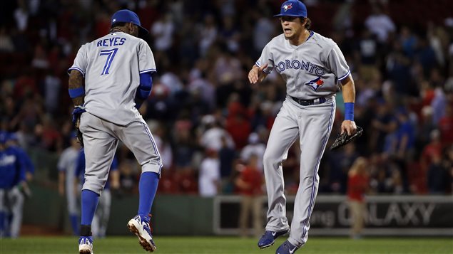 Blue Jays shortstop Jose Reyes (7) and centre fielder Colby Rasmus celebrate after their 6-1 victory over Boston at Fenway Park on Wednesday. The Jays are 11-3 since the All-Star Break. Both are wearing their light blue away uniforms and both are well off the ground in a victory leap. 